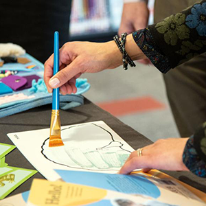 Person painting with a blue paintbrush