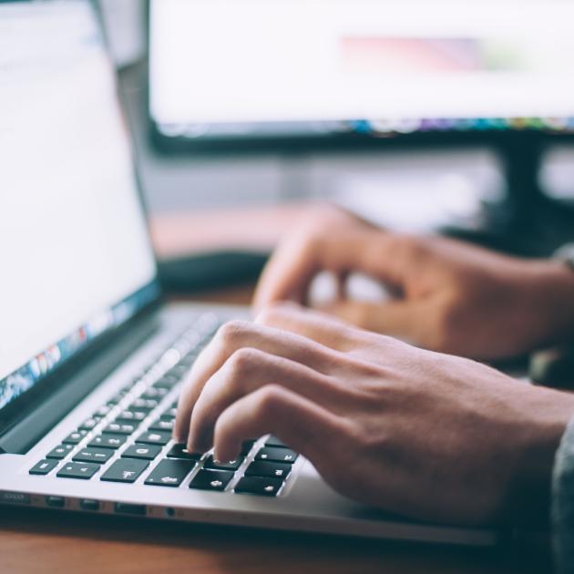 hands typing on a laptop