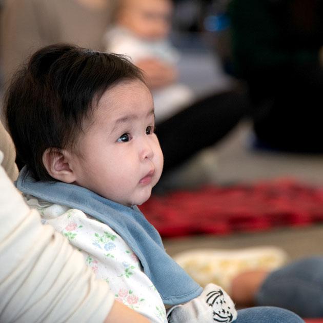 A photo of a baby listening to a story
