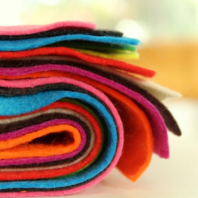 A close-up, colourful bundle of felt fabric sits tidy on a table