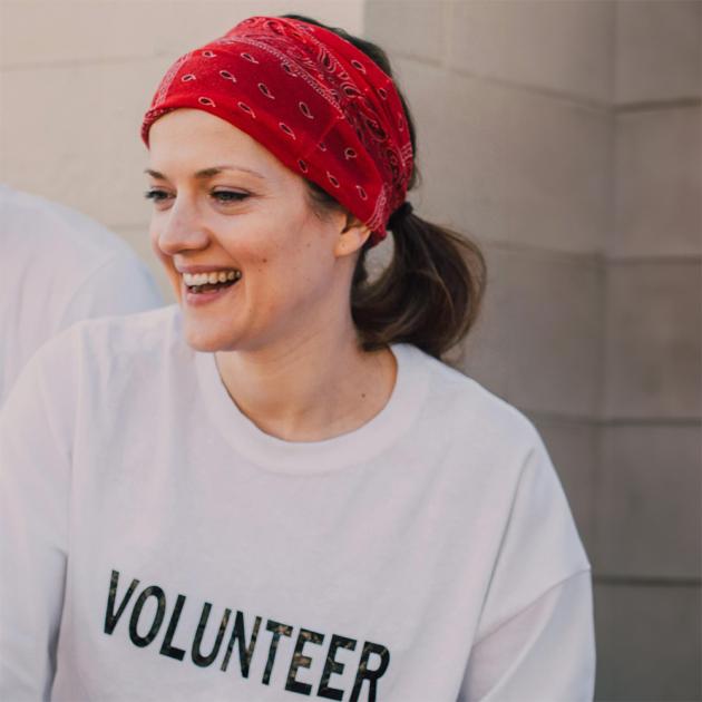 woman wearing red bandana in hair with white t-shirt with the word volunteer on the front