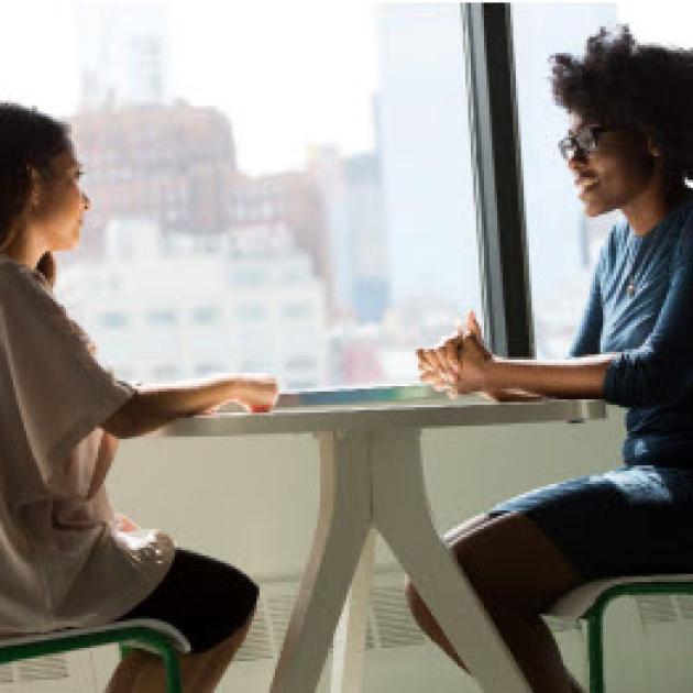 Two women sitting at a table talking