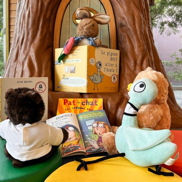 Stuffies sitting around a tree with French books