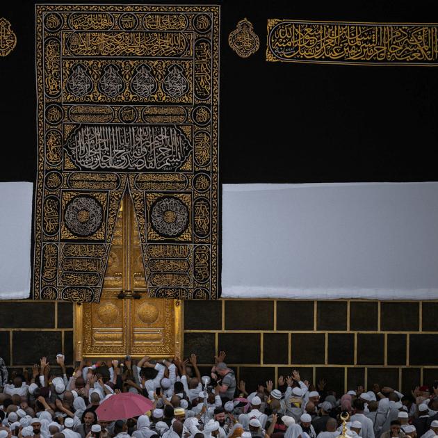 An photograph of people praying in front of the Kaba 