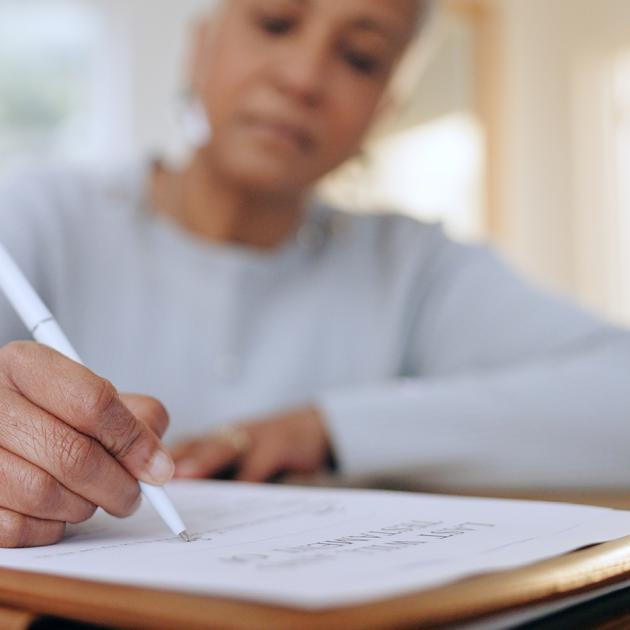 Senior woman filling in last will and testament form