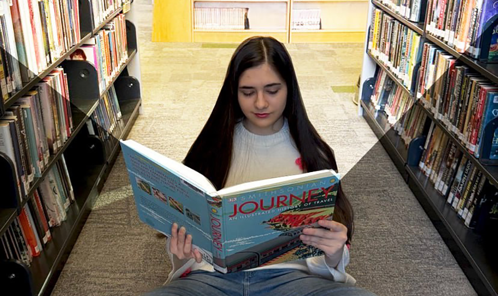 Teen girl sitting on the floor reading a book